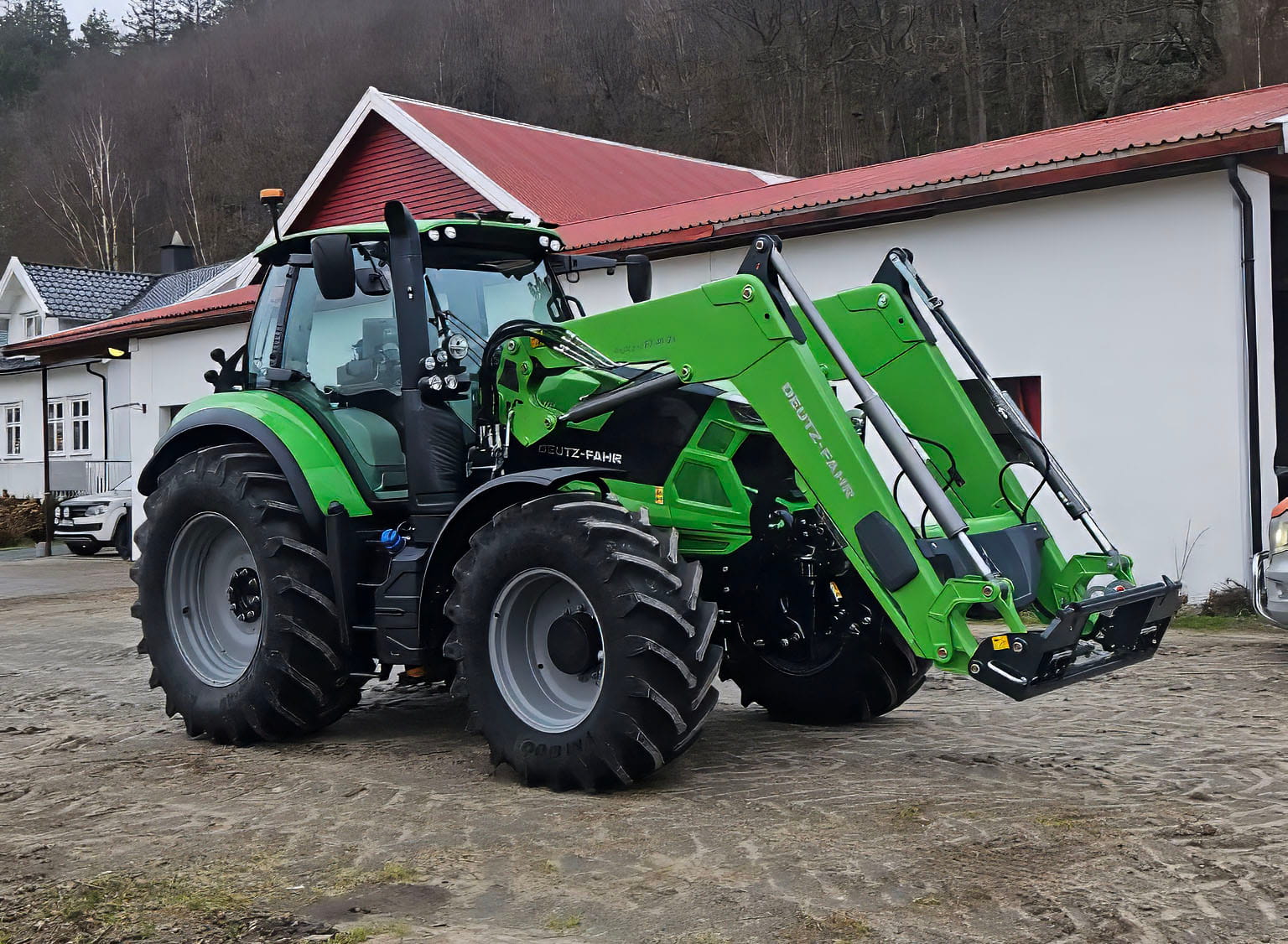 Grønn Deutz-Fahr traktor på gårdsplass
