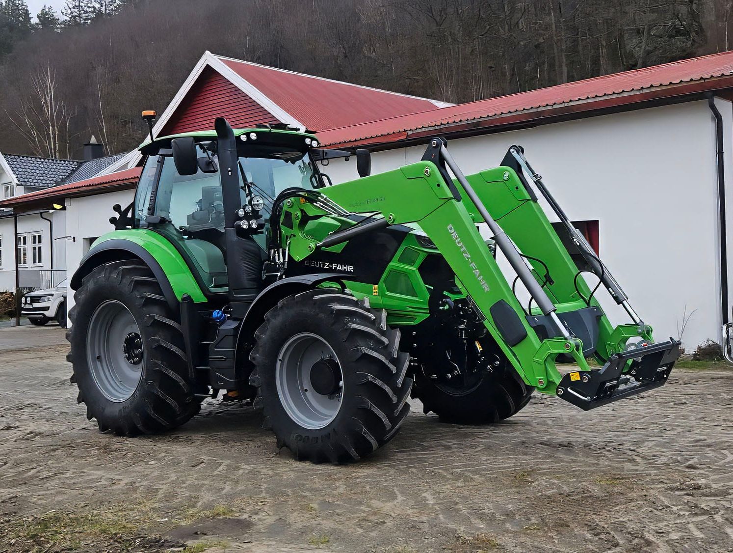 Grønn Deutz-Fahr traktor på gårdsplass